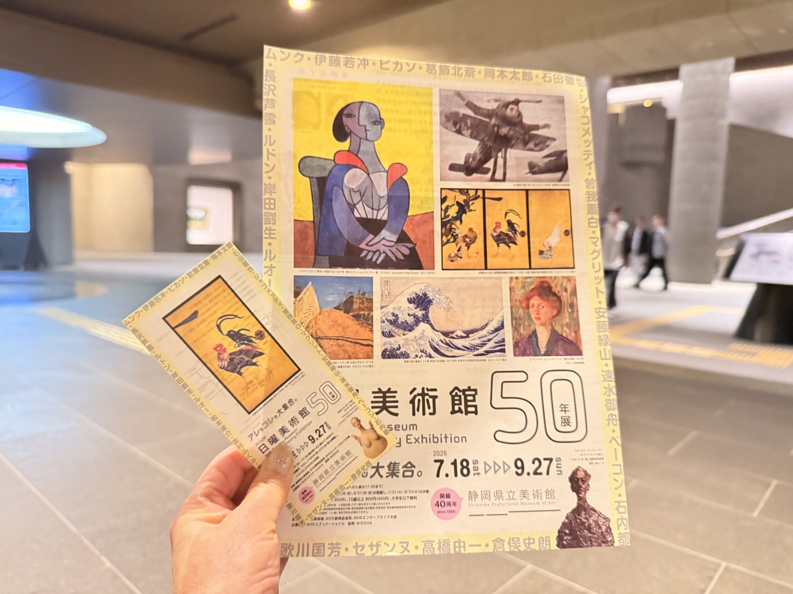 「NHK日曜美術館 50年展」のチケットとチラシを手に持っているところ